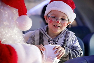 Air Transat et la Fondation Rêves d'enfants ont emmené aujourd'hui des centaines d'enfants vers le pôle Nord, au départ de Montréal Toronto et Calgary, pour ramener le père Noël. Sur la photo : le père Noël et un enfant parrainé par la Fondation. (Groupe CNW/Transat A.T. inc.)