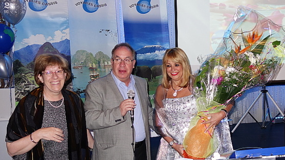 Collaborateurs de longue date de Voyages Cassis, Gisèle Desmarais et Bruno Pilote remettent à la présidente, Évelyn Cassis, au nom de toute l'équipe, un imposant bouquet pour la remercier d'être qui elle est.