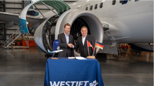 Alexis von Hoensbroech, chef de la direction de WestJet, et Harald Gloy, chef de l’exploitation de Lufthansa Technik signent un contrat d’entretien de moteurs d’avions historiques à Calgary.