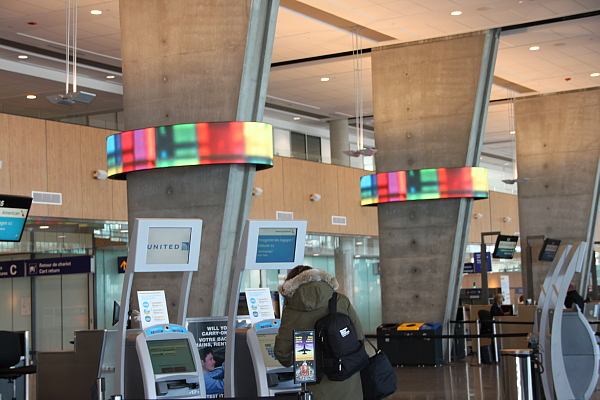 Aéroport international MONTRÉAL-TRUDEAU Innove avec deux écrans d’art numérique en forme elliptique Artiste : Caroline Bergeron, Montréal en couleurs montre l’architecture de la Métropole